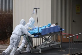 Nhân viên y tế chuyển bệnh nhân COVID-19 vào bệnh viện ở Seoul, Hàn Quốc ngày 14/3/2022. (Ảnh: Yonhap/TTXVN) 