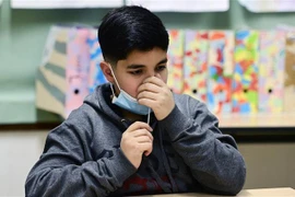 Một học sinh tự lấy mẫu xét nghiệm nhanh COVID-19 tại trường học ở Bonn, Đức. (Ảnh: AFP/TTXVN) 