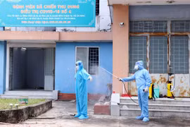 Các bác sỹ bệnh viện dã chiến thu dung, điều trị COVID-19 số 4 khử khuẩn toàn thân cho nhau sau ca trực. (Ảnh: Xuân Khu/TTXVN)