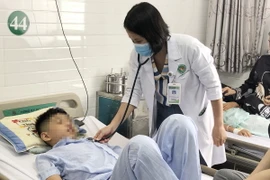 Bác sỹ khám cho các học sinh bị nghi ngộ độc thực phẩm sau khi ăn cơm cuộn bán trước cổng trường. (Ảnh: Đinh Hằng/TTXVN)