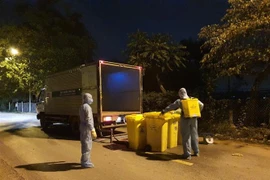 Thu gom rác thải tại thôn Hạ Lôi để xử lý theo quy trình rác thải y tế. (Ảnh: Mạnh Khánh/TTXVN) 