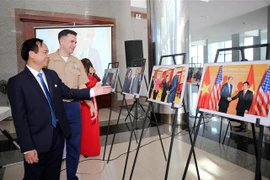 Thiếu tá Chuck Casey, Tùy viên Thủy quân Lục chiến Hoa Kỳ tại Việt Nam và ông Võ Văn Hưng, Chủ tịch UBND tỉnh Quảng Trị xem triển lãm. (Ảnh: Hồ Cầu/TTXVN) 