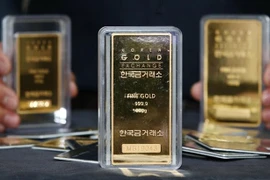 Nhân viên giới thiệu các thanh vàng tại cửa hàng ở Seoul, Hàn Quốc. (Nguồn: YONHAP/TTXVN) 