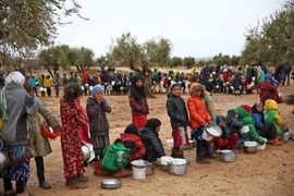 Trẻ em xếp hàng nhận lương thực cứu trợ tại tỉnh Aleppo, Syria. (Ảnh: AFP/TTXVN)