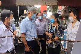 Thứ trưởng Bộ Y tế Nguyễn Trường Sơn thăm hỏi cán bộ địa phương tại hẻm 251, phường 10, quận Gò Vấp đang bị phong tỏa do có 2 ca mắc COVID-19. (Ảnh: Đinh Hằng/TTXVN) 