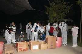 Công dân bỏ đồ bảo hộ y tế để làm thủ tục vào khu cách ly tập trung. (Ảnh minh họa: Thanh Hải/TTXVN) 