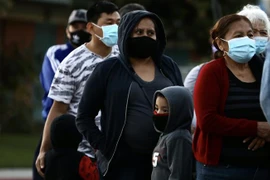 Người dân đeo khẩu trang phòng lây nhiễm COVID-19 khi xếp hàng chờ nhận hàng phân phát tại Los Angeles, California, Mỹ, ngày 19/11/2020. (Nguồn: THX/TTXVN) 