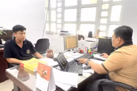 Công an làm việc với Phùng Thế Tài (áo đen) cầm đầu đường dây cá độ bóng đá. (Ảnh: TTXVN phát)