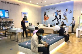 Thực hiện giãn cách xã hội và các biện pháp phòng ngừa lây lan của dịch COVID-19 tại một cửa hàng điện thoại di động ở Bangkok vừa mở cửa trở lại ngày 5/5. (Ảnh: Ngọc Quang/TTXVN) 