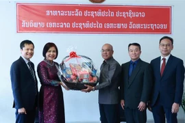Đại sứ Lê Thị Tuyết Mai, Trưởng Phái đoàn thường trực Việt Nam (áo dài), chúc mừng Phái đoàn thường trực Lào tại Geneva. (Ảnh: Nguyễn Tuấn/TTXVN)