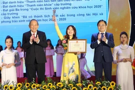 Phó Thủ tướng Thường trực Trương Hòa Bình và ông Nguyễn Anh Tuấn (bên phải), Bí thư thứ nhất Trung ương Đoàn, Chủ tịch Hội Liên hiệp Thanh niên Việt Nam tuyên dương 'Sinh viên 5 tốt' cấp Trung ương. (Ảnh: Văn Điệp/TTXVN) 