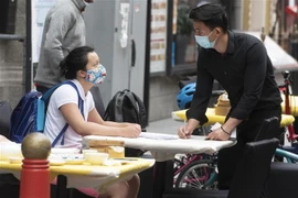Người dân đeo khẩu trang tại một nhà hàng ở London, Anh, ngày 4/7. (Nguồn: AFP/TTXVN) 