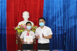 Đại diện lãnh đạo Tỉnh đoàn Gia Lai đã trao tặng huy hiệu Tuổi trẻ dũng cảm cho em Trần Nguyễn Anh Duy, Trường Trung học cơ sở Nguyễn Văn Cừ, xã Biển Hồ, thành phố Pleiku. (Ảnh: Hồng Điệp/TTXVN)