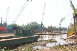 Thi công đắp đập tạm ngăn mặn trên sông Ba Lai. (Ảnh: Công Trí/TTXVN) 