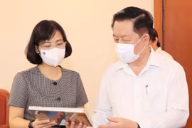 Phó Tổng Giám đốc Thông tấn xã Việt Nam Vũ Việt Trang giới thiệu các ấn phẩm của TTXVN với đồng chí Nguyễn Trọng Nghĩa, Bí thư Trung ương Đảng, Trưởng ban Tuyên giáo Trung ương. (Ảnh: Nguyễn Điệp/TTXVN)