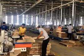 Sản xuất đồ gỗ tại Công ty Trách nhiệm hữu hạn Một thành viên Triệu Phú Lộc, thị xã Tân Uyên. (Ảnh: Chí Tưởng/TTXVN)