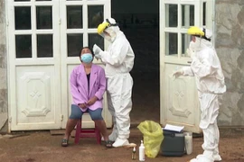 Lấy mẫu xét nghiệm sàng lọc trên diện rộng cho người dân xã Quảng Tín. (Ảnh: TTXVN phát) 