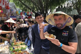 Chủ tịch quận Mauricio Tabe Echartea thưởng thức món nem rán của Việt Nam. (Ảnh: Lưu Việt Hùng/TTXVN) 