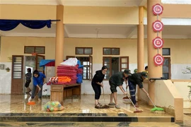 Giáo viên và cán bộ, chiến sỹ của thuộc Tiểu đoàn 2, Trung đoàn cảnh sát cơ động Bắc Trung Bộ dọn bùn đất tại trường mầm non Hương Thủy, huyện Hương Khê. (Ảnh: Hữu Quyết/TTXVN)