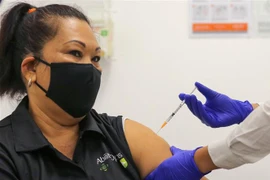 Nhân viên y tế tiêm vaccine phòng COVID-19 cho người dân tại Sydney, Australia. (Ảnh: AFP/TTXVN) 