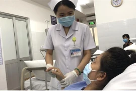 Bác sỹ thăm khám cho sản phụ sau phẫu thuật. (Nguồn: TTXVN phát) 