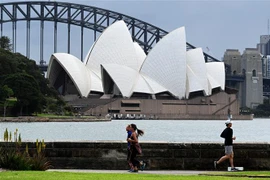 Người dân tập thể dục tại khu vực Cầu Cảng ở thành phố Sydney, Australia. (Ảnh: AFP/TTXVN) 