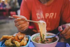 The Travel miêu tả món phở nổi tiếng nhờ nước dùng thơm ngon nóng hổi, sợi phở trắng dẻo, ăn cùng thịt bò hoặc thịt gà và các loại rau thơm. (Ảnh: Lê Minh Sơn/Vietnam+) 
