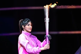 Vận động viên bơi Xu Jialing đã thắp sáng vạc lửa bằng cánh tay sinh học thông minh. (Nguồn: Xinhua)