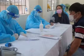 Nhân viên Y tế khám sàng lọc cho người dân trước khi tiêm vaccine COVID-19. (Ảnh: Xuân Triệu/TTXVN) 