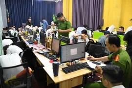 Cơ quan chức năng kiểm tra, khám xét, thu giữ vật chứng tại nơi làm việc của các đối tượng. (Ảnh: TTXVN phát) 