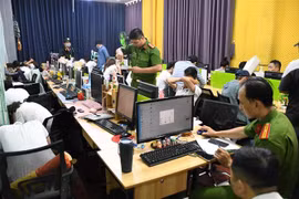 Cơ quan chức năng kiểm tra, khám xét, thu giữ vật chứng tại nơi làm việc của các đối tượng. (Ảnh: TTXVN phát) 