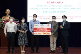 Ông Nguyễn Thành Trung, Phó Chủ tịch Thường trực Ủy ban Mặt trận Tổ quốc Việt Nam Thành phố Hồ Chí Minh tiếp nhận bảng tượng trưng sự ủng hộ của Tập đoàn Sovico, HDBank, Vietjet. (Ảnh: Xuân Khu/TTXVN) 