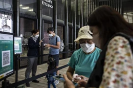 Người dân trình thẻ tiêm vaccine ngừa COVID-19 trước khi vào viện bảo tàng ở Hong Kong, Trung Quốc, ngày 21/4/2022. (Ảnh: AFP/TTXVN) 