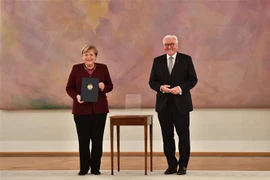 Tổng thống Đức Frank-Walter Steinmeier (phải) sau khi trao quyết định kết thúc nhiệm kỳ công tác cho Thủ tướng Angela Merkel (trái) tại Cung điện Bellevue ở Berlin ngày 26/10/2021. (Ảnh: AFP/TTXVN) 