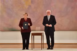 Tổng thống Đức Frank-Walter Steinmeier (phải) sau khi trao quyết định kết thúc nhiệm kỳ công tác cho Thủ tướng Angela Merkel (trái) tại Cung điện Bellevue ở Berlin ngày 26/10/2021. (Ảnh: AFP/TTXVN) 
