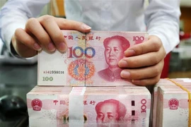 Nhân viên kiểm đồng 100 Nhân dân tệ tại ngân hàng ở tỉnh Giang Tô, Trung Quốc. (Ảnh: AFP/TTXVN)