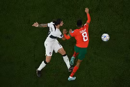 Pha tranh bóng giữa Azzedine Ounahi (phải) và tiền vệ Bồ Đào Nha Ruben Neves. (Ảnh: AFP/TTXVN)