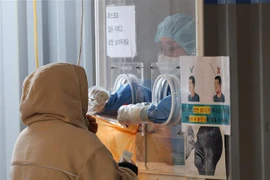 Nhân viên y tế lấy mẫu xét nghiệm COVID-19 cho người dân tại Seoul, Hàn Quốc, ngày 23/1/2022. (Ảnh: Yonhap/TTXVN) 