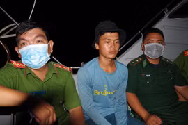 Đối tượng Bùi Tuấn Kha (giữa) bị Bộ đội Biên phòng và Công an địa phương áp giải. (Ảnh: Hữu Chí/TTXVN)