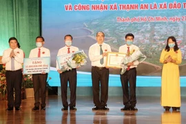 Chủ tịch Ủy ban Nhân dân Thành phố Hồ Chí Minh Nguyễn Thành Phong (trái, ngoài cùng) và nguyên Bí thư Thành ủy Thành phố Hồ Chí Minh Nguyễn Thiện Nhân (thứ 3 phải sang) trao quyết định của Thủ tướng Chính phủ về công nhận huyện Cần Giờ đạt chuẩn nông thôn