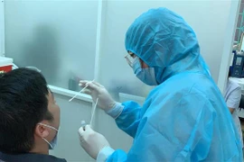 Nhân viên Trung tâm Y tế Quận 3 lấy mẫu xét nghiệm cho người dân. (Ảnh: Đinh Hằng/TTXVN)