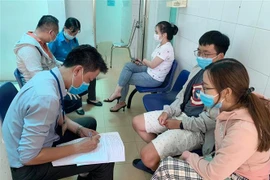 Người dân khai báo y tế tại Trung tâm Y tế Quận 3. (Ảnh: Đinh Hằng/TTXVN)