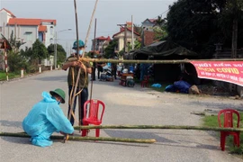 Lực lượng chức năng lập 5 chốt phong tỏa thôn Quan Nhân, xã Nhân Đạo, huyện Lý Nhân, Hà Nam. (Ảnh: Nguyễn Chinh/TTXVN)