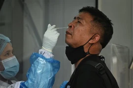 Nhân viên y tế lấy mẫu xét nghiệm COVID-19 cho người dân tại Bangkok, Thái Lan. (Ảnh: AFP/TTXVN)