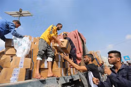 Người dân chuyển hàng cứu trợ nhân đạo tại cửa khẩu Rafah ở Dải Gaza. (Ảnh: THX/TTXVN)