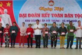 Ông Dương Sà Kha, Chủ tịch Ủy ban MTTQ Việt Nam tỉnh Sóc Trăng tặng quà cho hộ nghèo tại khu dân cư xã Mỹ Quới, thị xã Ngã Năm, tỉnh Sóc Trăng. (Ảnh Tuấn Phi/TTXVN)