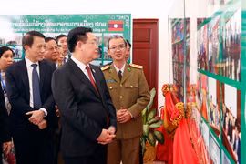 Chủ tịch Quốc hội Vương Đình Huệ xem trưng bày ảnh tại Học viện Chính trị Công an Lào. (Ảnh: Doãn Tấn/TTXVN)