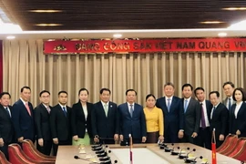 Bí thư Thành ủy Hà Nội Đinh Tiến Dũng chụp ảnh lưu niệm với đoàn đại biểu cấp cao thủ đô Vientiane, Lào. (Ảnh: Tuyết Mai/TTXVN)