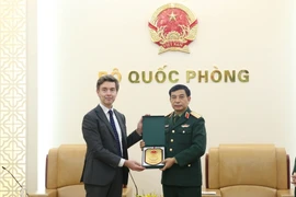 Đại tướng Phan Văn Giang tặng quà lưu niệm ông Julien Guerrier. (Ảnh: Hồng Pha/TTXVN phát)