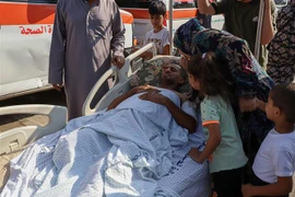 Người bị thương chờ được đưa tới các bệnh viện ở Ai Cập qua cửa khẩu Rafah ngày 1/11. (Ảnh: THX/TTXVN)